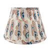 Indian block print pleated lampshade with neutral background with a soft red and blue block print.
